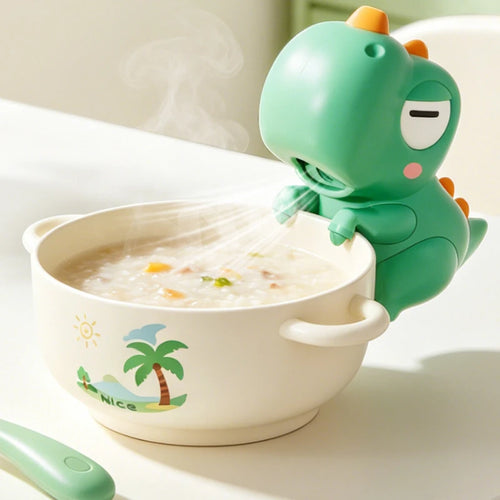 Soplador de sopa con forma de dinosaurio verde enfriando un bol de papilla